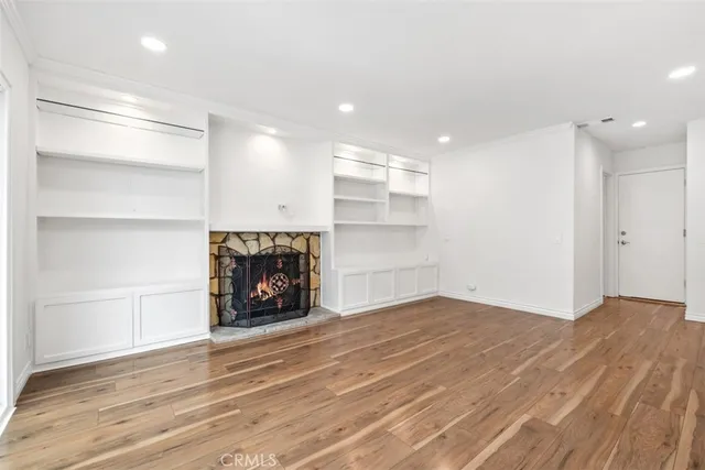 a view of an empty room with a fireplace and a window