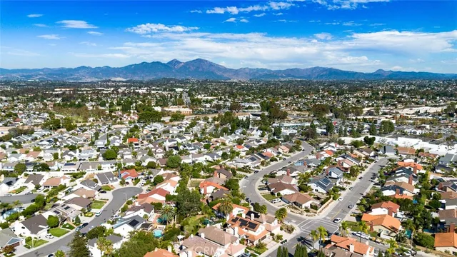 an aerial view of residential houses with outdoor space and trees