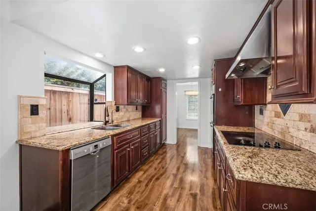 a kitchen with stainless steel appliances granite countertop a stove and a sink