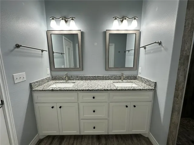 a bathroom with a granite countertop sink and a mirror