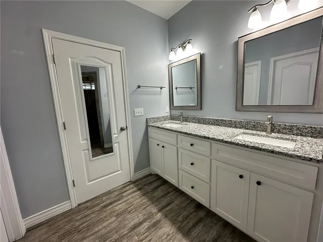 a bathroom with a granite countertop sink and a mirror