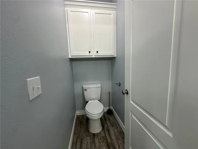 a bathroom with a granite countertop toilet and a sink