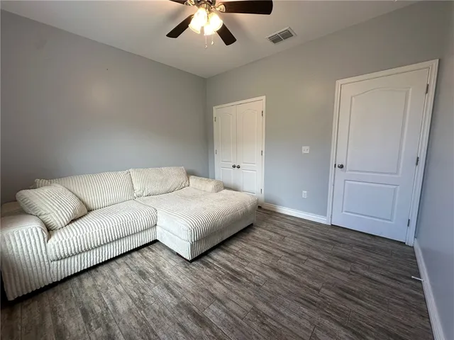 a living room with furniture and a wooden floor