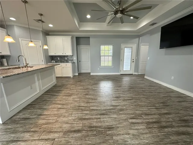 a large kitchen with cabinets wooden floor and a fireplace