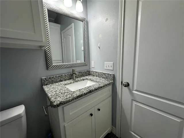 a bathroom with a granite countertop sink and a mirror
