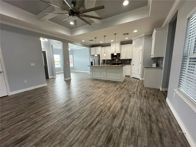 a view of kitchen with cabinets wooden floor and stainless steel appliances