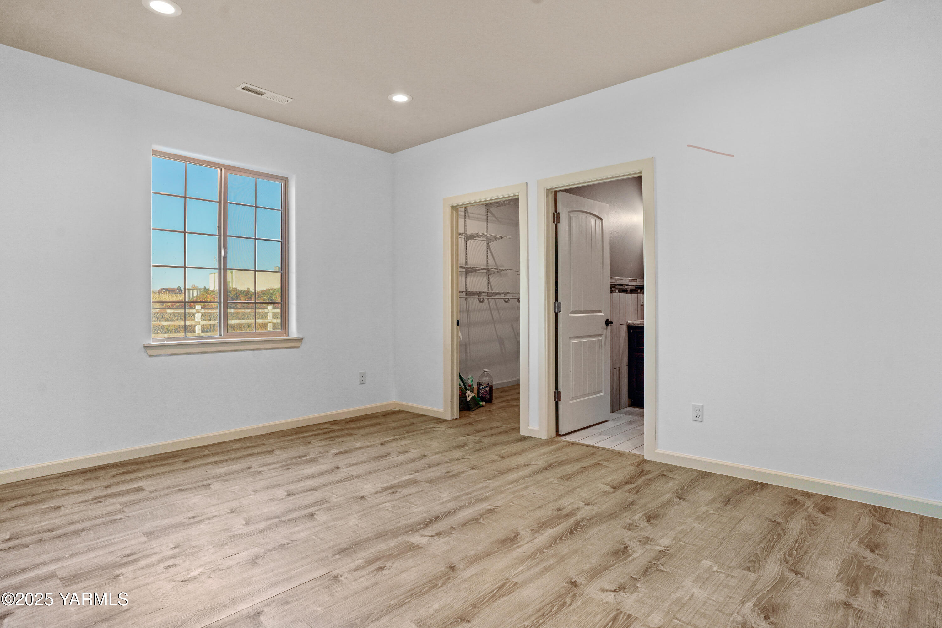 10002 North Wamba Road Prosser, WA 99350 - Photo 19 of 40 a view of an empty room with wooden floor and window