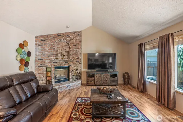 a living room with furniture a flat screen tv and a fireplace
