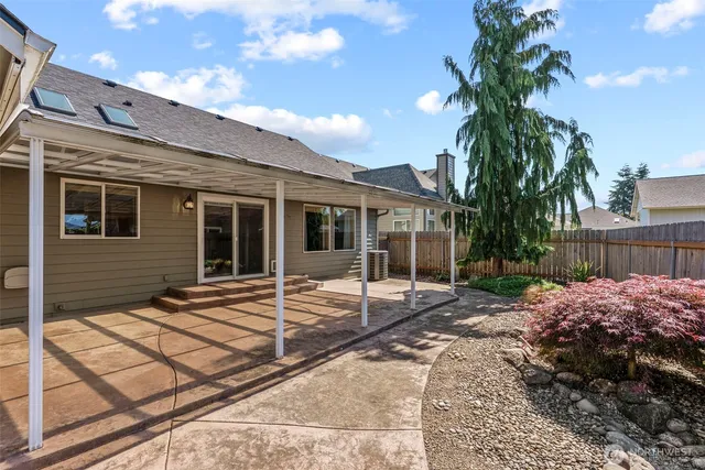 a view of a house with backyard and sitting area