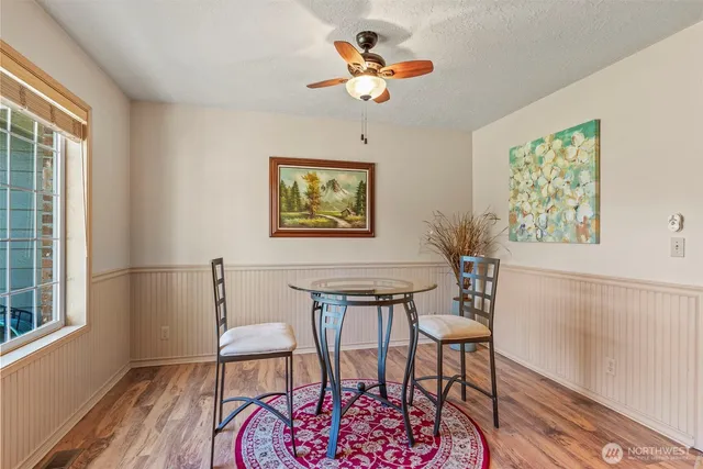 a view of a dining room with furniture a chandelier and wooden floor