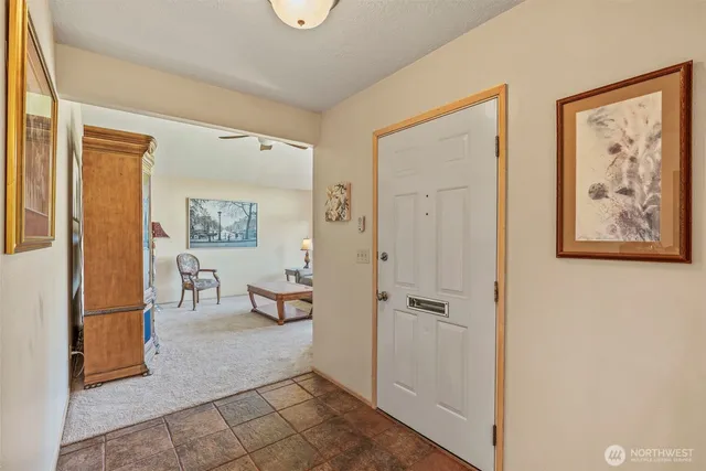 a view of a hallway with wooden floor and a bathroom
