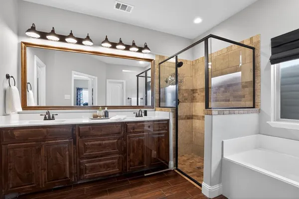 a bathroom with double vanity sinks and a bathtub