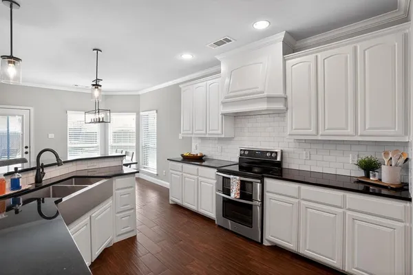 a kitchen with granite countertop a sink stainless steel appliances and cabinets
