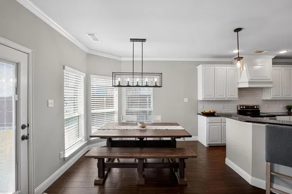 a kitchen with kitchen island granite countertop a stove a sink and wooden floors