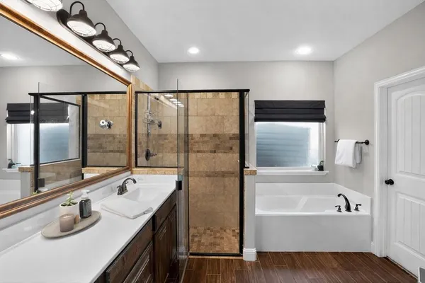 a bathroom with a granite countertop sink a bathtub and shower