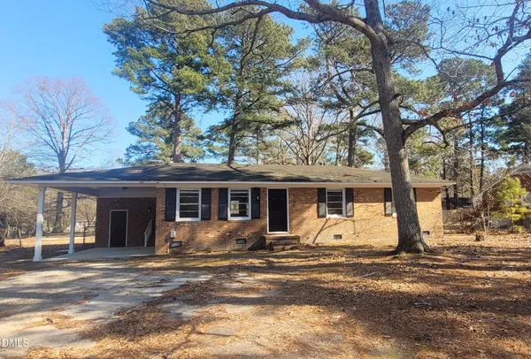 a view of a house with a yard and large tree