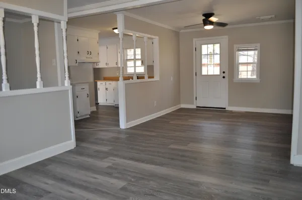 an empty room with wooden floor and windows