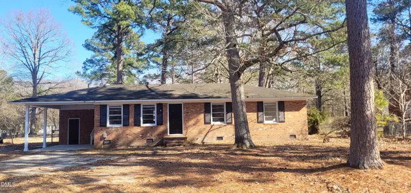a front view of a house with a tree in front of it