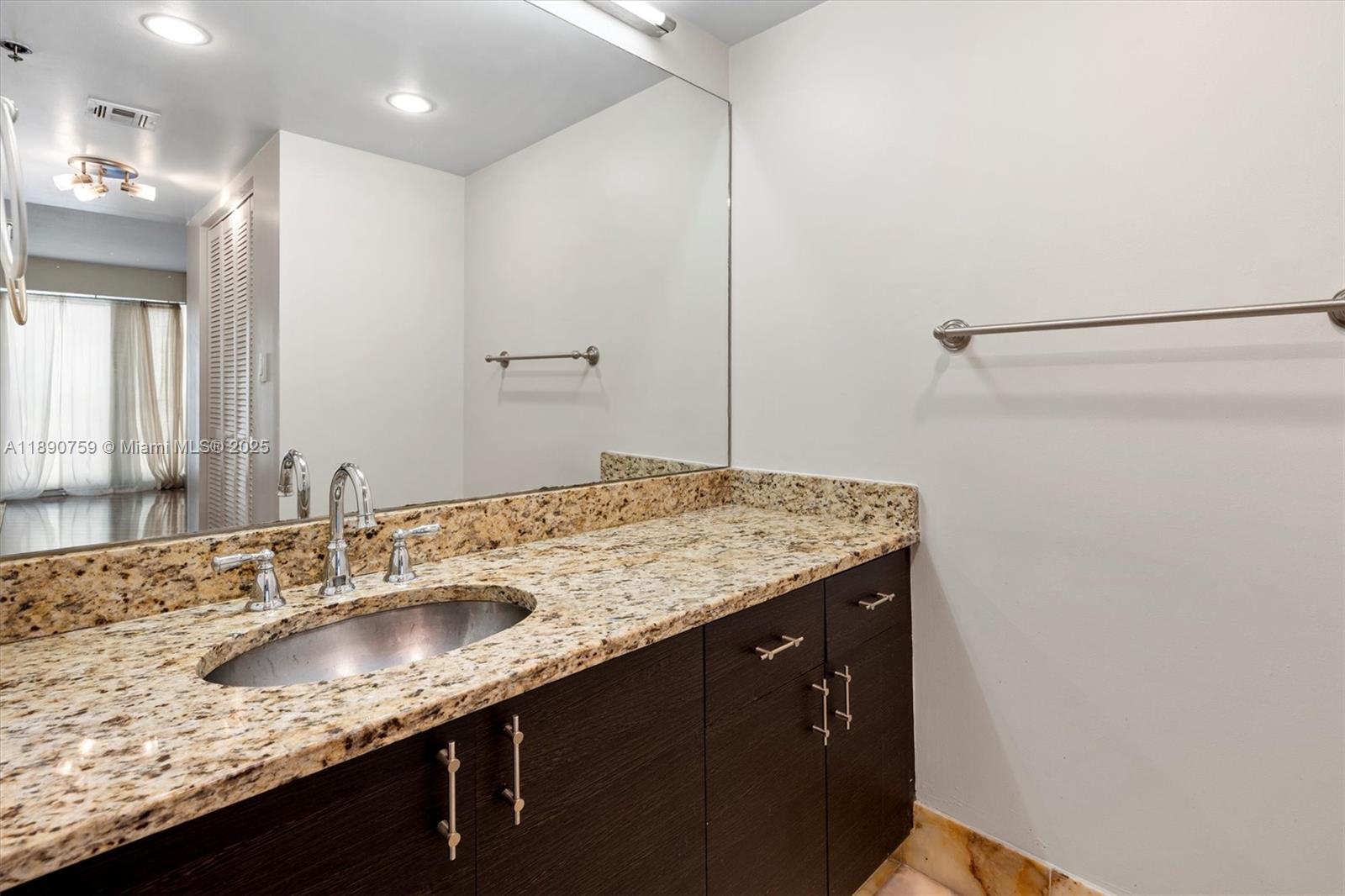 2351 Douglas Road, Unit 906 Miami, FL 33145 - Photo 28 of 45 a bathroom with a granite countertop sink and a mirror
