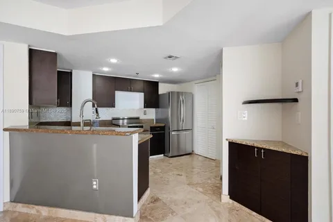 a kitchen with stainless steel appliances granite countertop a refrigerator a sink and a stove
