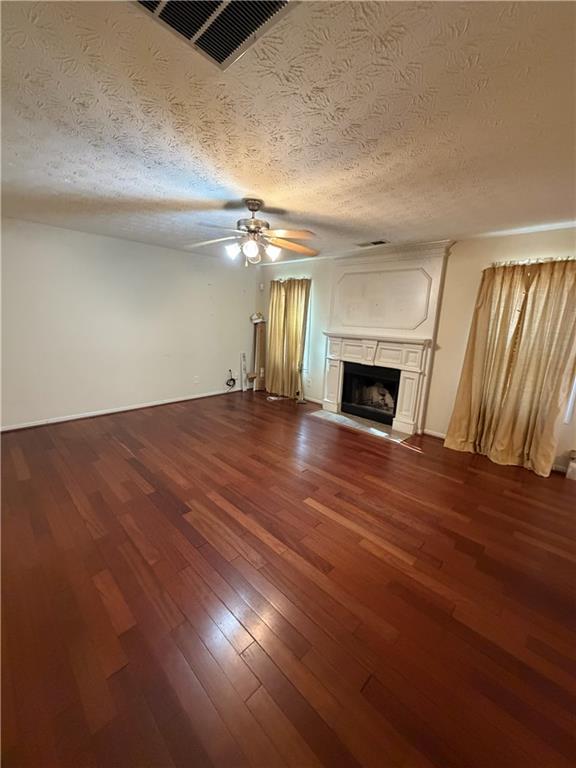 829 Sweden Forest Cove Hampton, GA 30228 - Photo 4 of 9 an empty room with wooden floor fireplace and windows