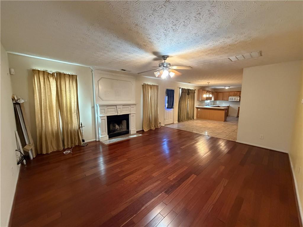 829 Sweden Forest Cove Hampton, GA 30228 - Photo 5 of 9 an empty room with wooden floor and fireplace