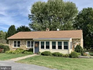 a front view of a house with a yard and potted plants