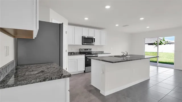 a kitchen with stainless steel appliances granite countertop a sink and a stove