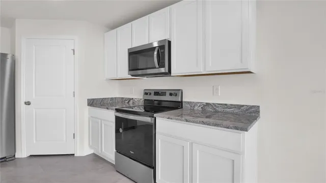 a kitchen with stainless steel appliances granite countertop a sink and a refrigerator