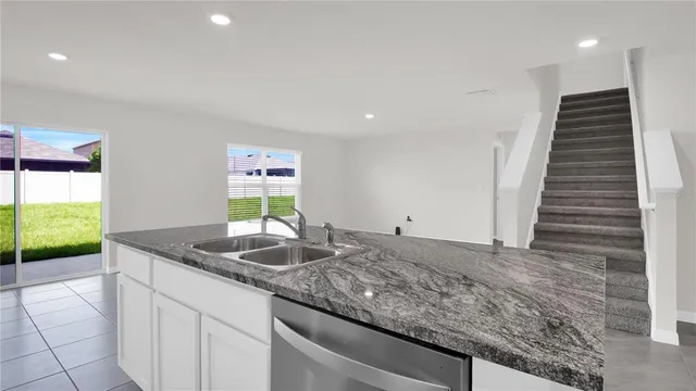 a kitchen with stainless steel appliances granite countertop a sink a stove and a microwave