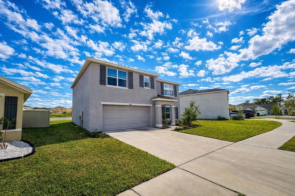 16632 Windmill Forge Pass Wimauma, FL 33598 - Photo 2 of 40 a front view of a house with a yard and garage