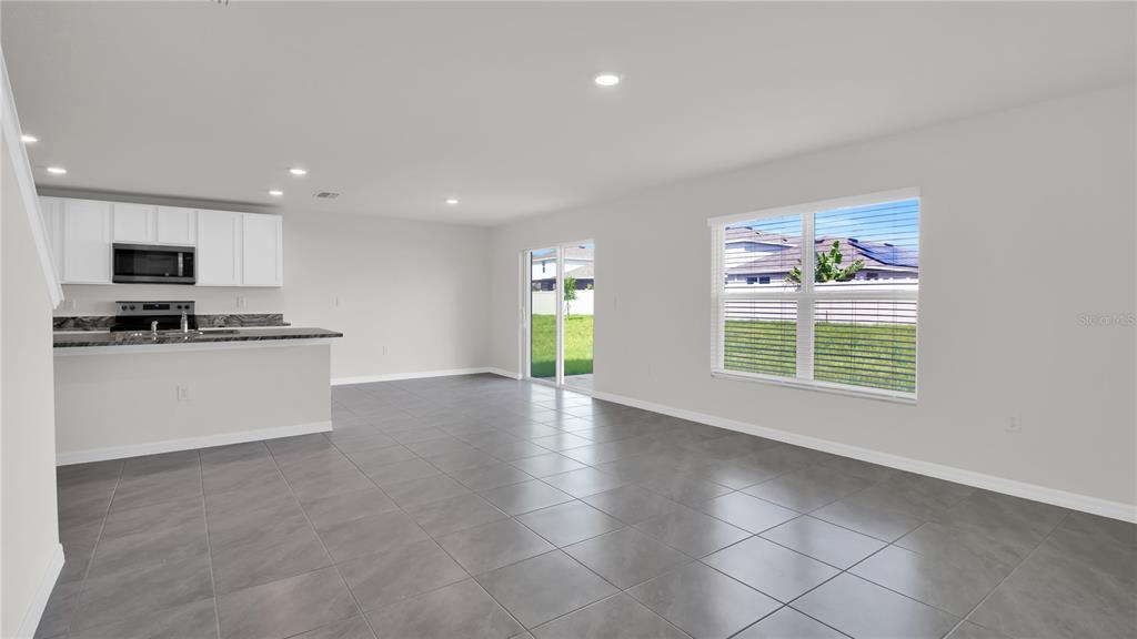 16632 Windmill Forge Pass Wimauma, FL 33598 - Photo 22 of 40 a view of an empty room with a window and kitchen view