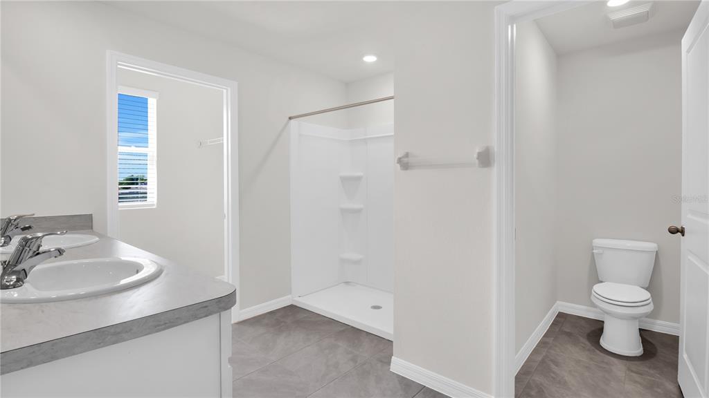 16632 Windmill Forge Pass Wimauma, FL 33598 - Photo 34 of 40 a bathroom with a sink a toilet and shower