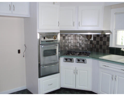 23 Drexel Street Springfield, MA 01104 - Photo 7 of 9 a kitchen with white cabinets and white appliances