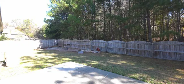 a view of a backyard with wooden fence