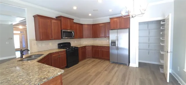 a kitchen with stainless steel appliances granite countertop a refrigerator stove top oven and sink
