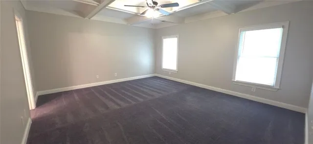 an empty room with a window and a ceiling fan