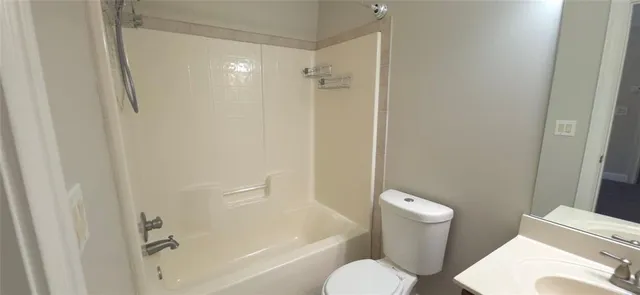 a white toilet sitting next to a bath tub