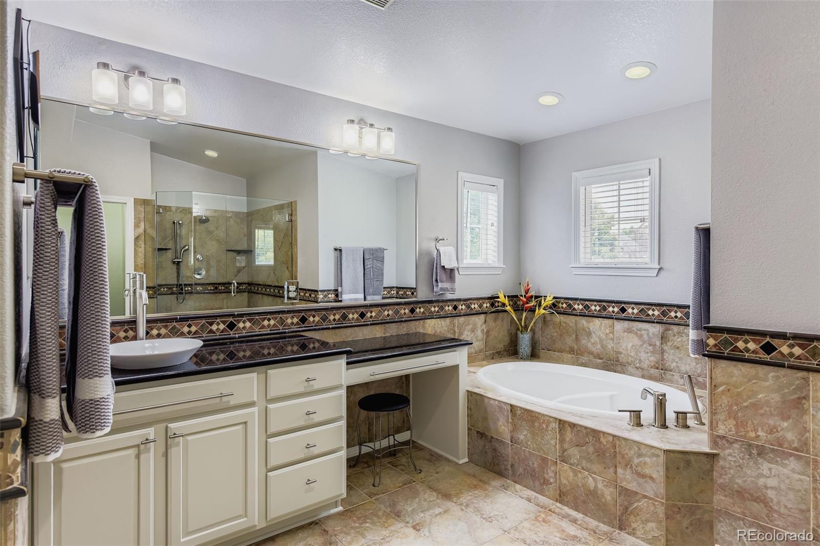 795 Ridgemont Circle Highlands Ranch, CO 80126 - Photo 15 of 35 a bathroom with a tub a sink and a mirror