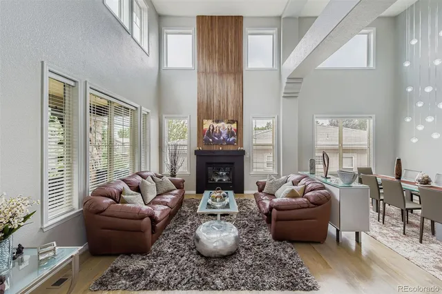 a living room with furniture a fireplace and a large window