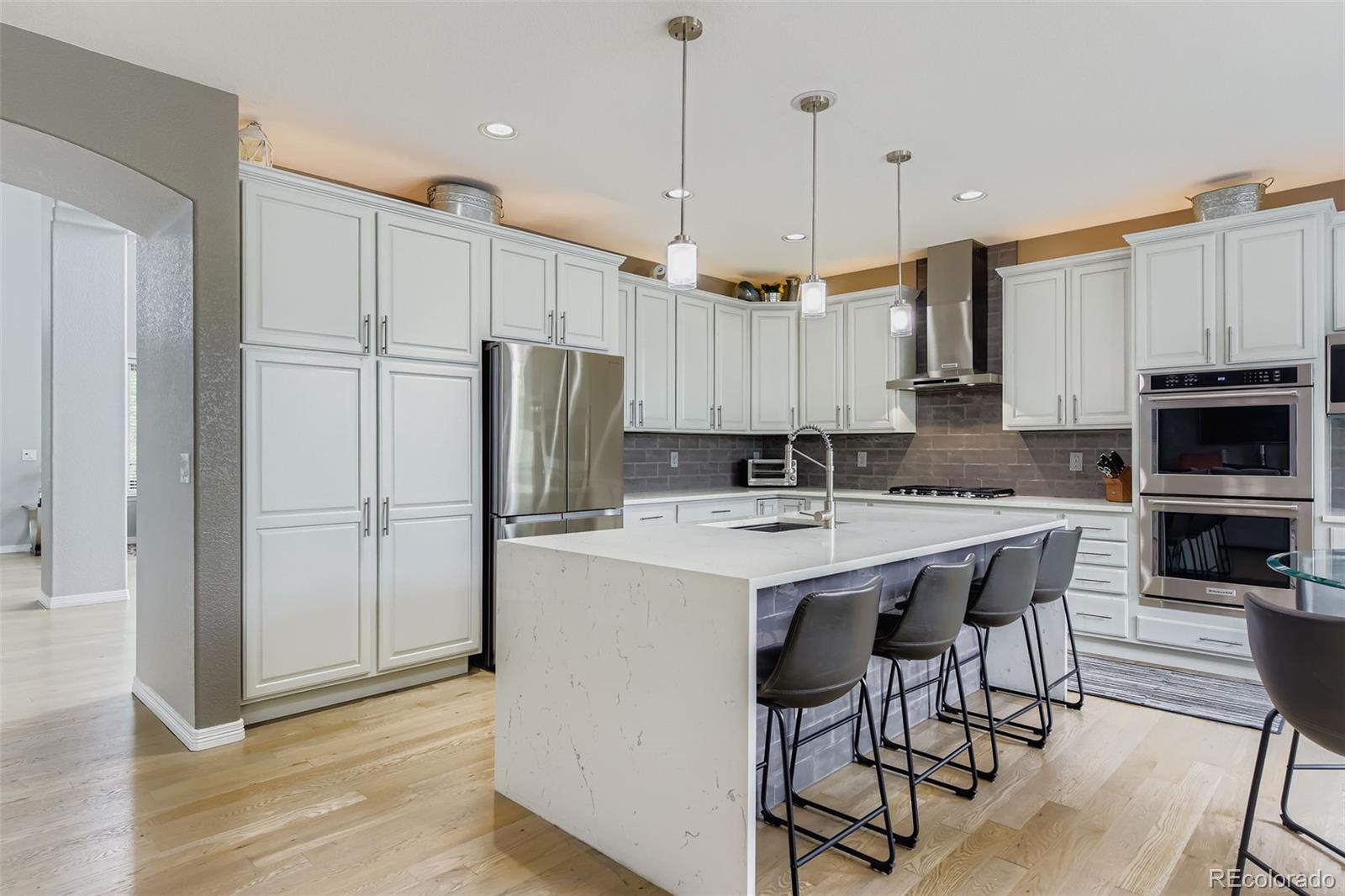 795 Ridgemont Circle Highlands Ranch, CO 80126 - Photo 9 of 35 a kitchen with kitchen island granite countertop a table chairs microwave and refrigerator