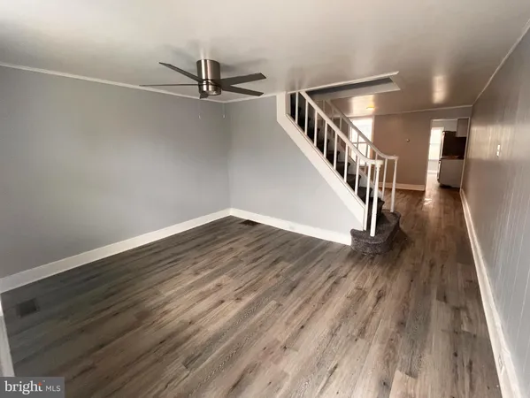 a view of a hallway with wooden floor and staircase