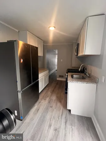 a kitchen with stainless steel appliances a refrigerator and wooden floor