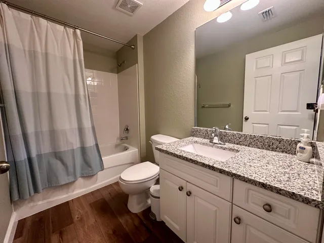 a bathroom with a granite countertop sink toilet and shower