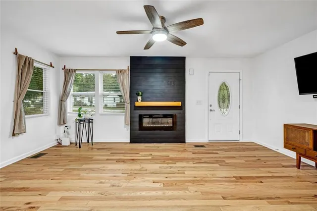 a view of a livingroom with wooden floor and a ceiling fan