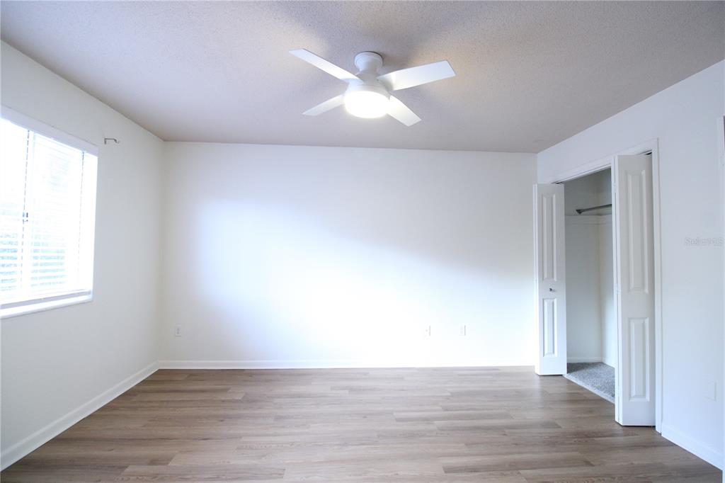 507 Northwest 39th Road, Unit 112 Gainesville, FL 32607 - Photo 11 of 23 an empty room with wooden floor and windows