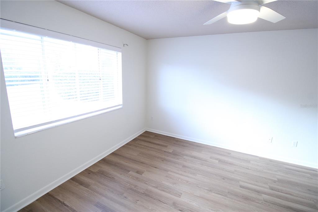 507 Northwest 39th Road, Unit 112 Gainesville, FL 32607 - Photo 12 of 23 an empty room with wooden floor and windows