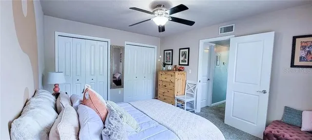 a bed room with a bed and a ceiling fan