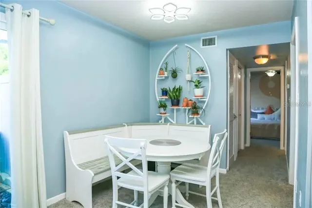 a view of a dining room with furniture and a chandelier