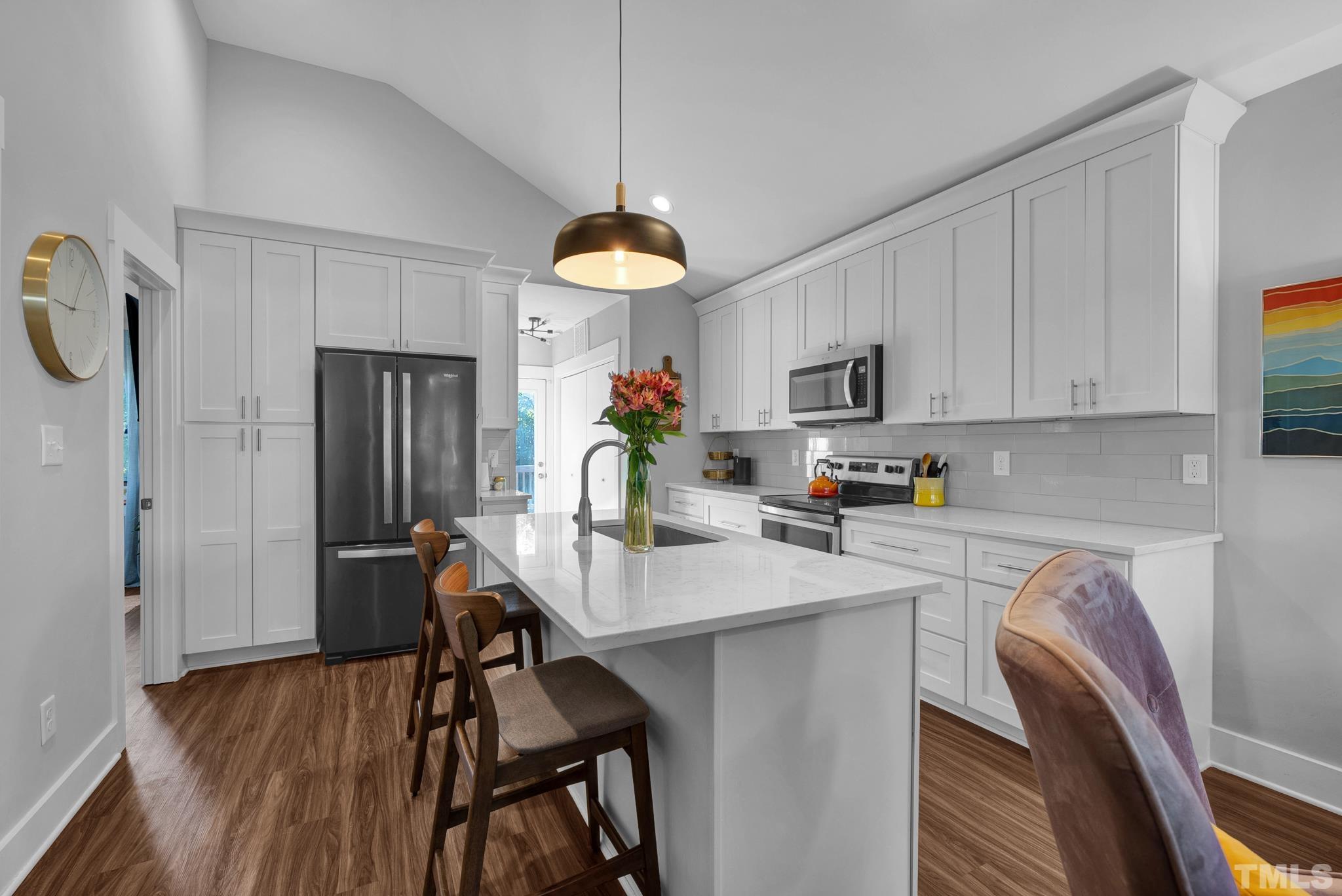 107 Bart Street Raleigh, NC 27610 - Photo 5 of 20 a kitchen with a table chairs refrigerator and microwave